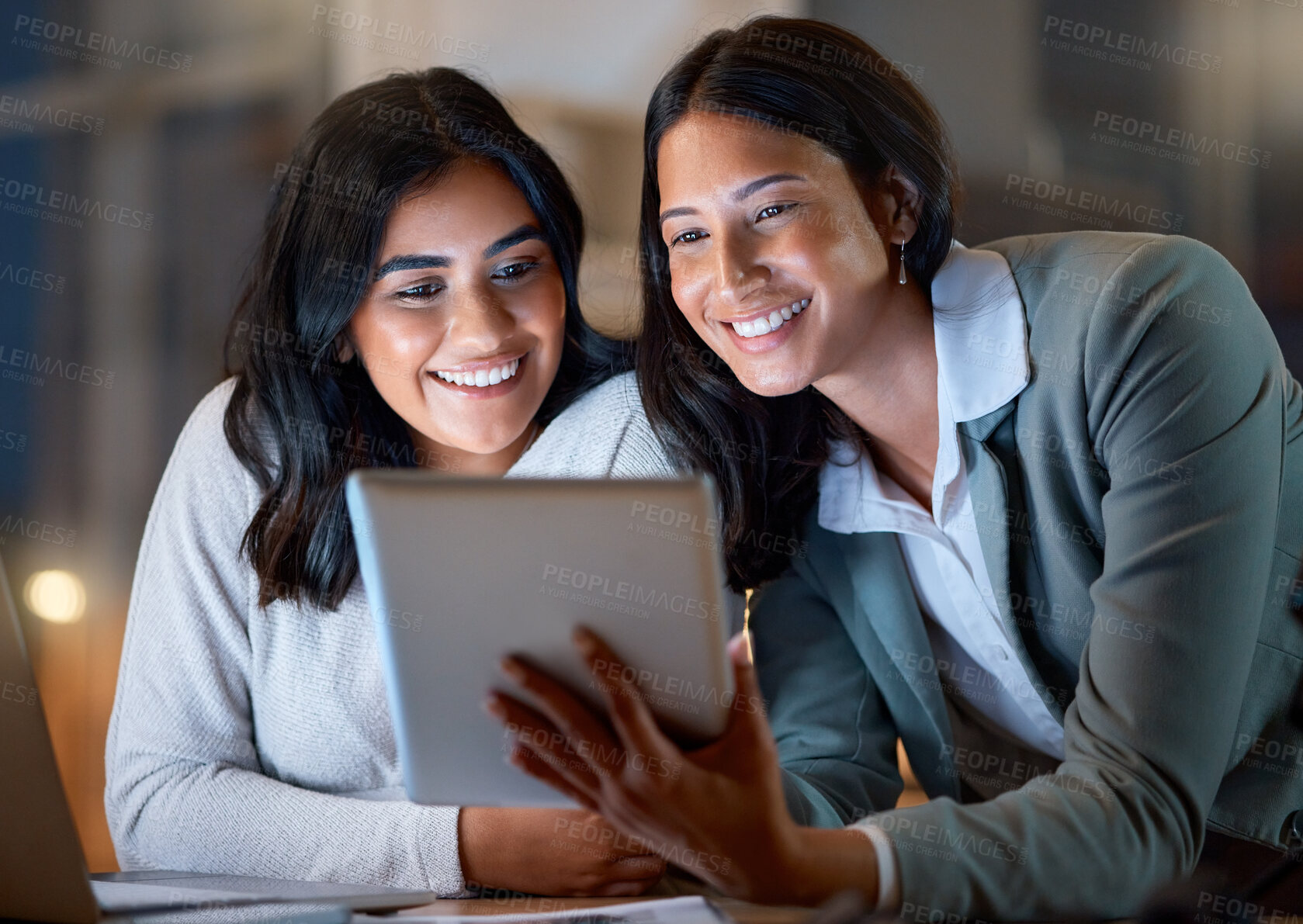 Buy stock photo Cropped shot of two attractive young businesswomen working late at their company offices