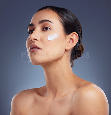 Buy stock photo Studio shot of a beautiful woman posing with moisturiser on her face