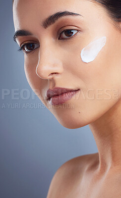Buy stock photo Studio shot of a beautiful woman posing with moisturiser on her face
