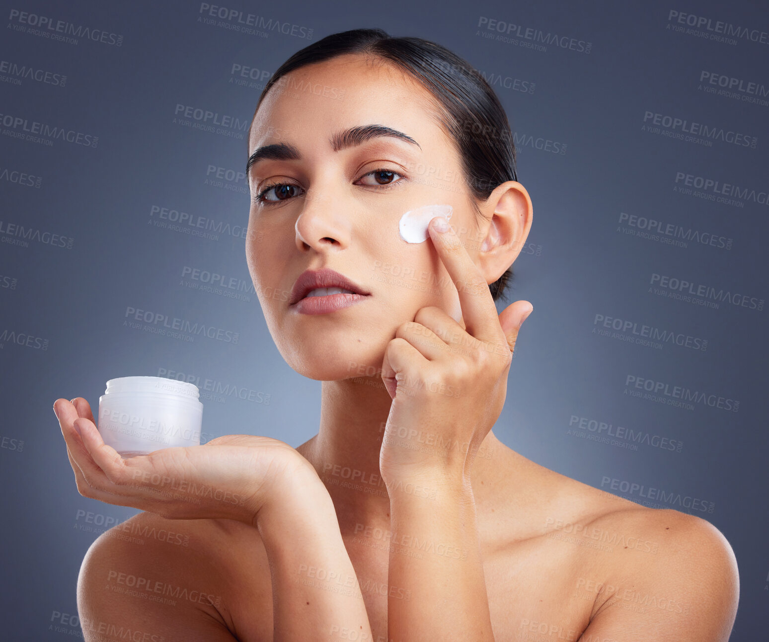 Buy stock photo Studio shot of a beautiful woman using a skincare product