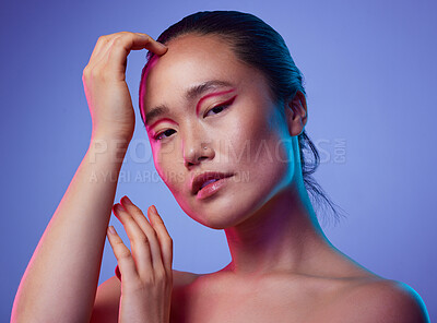 Buy stock photo Cropped shot of an attractive young woman posing in studio against a purple background