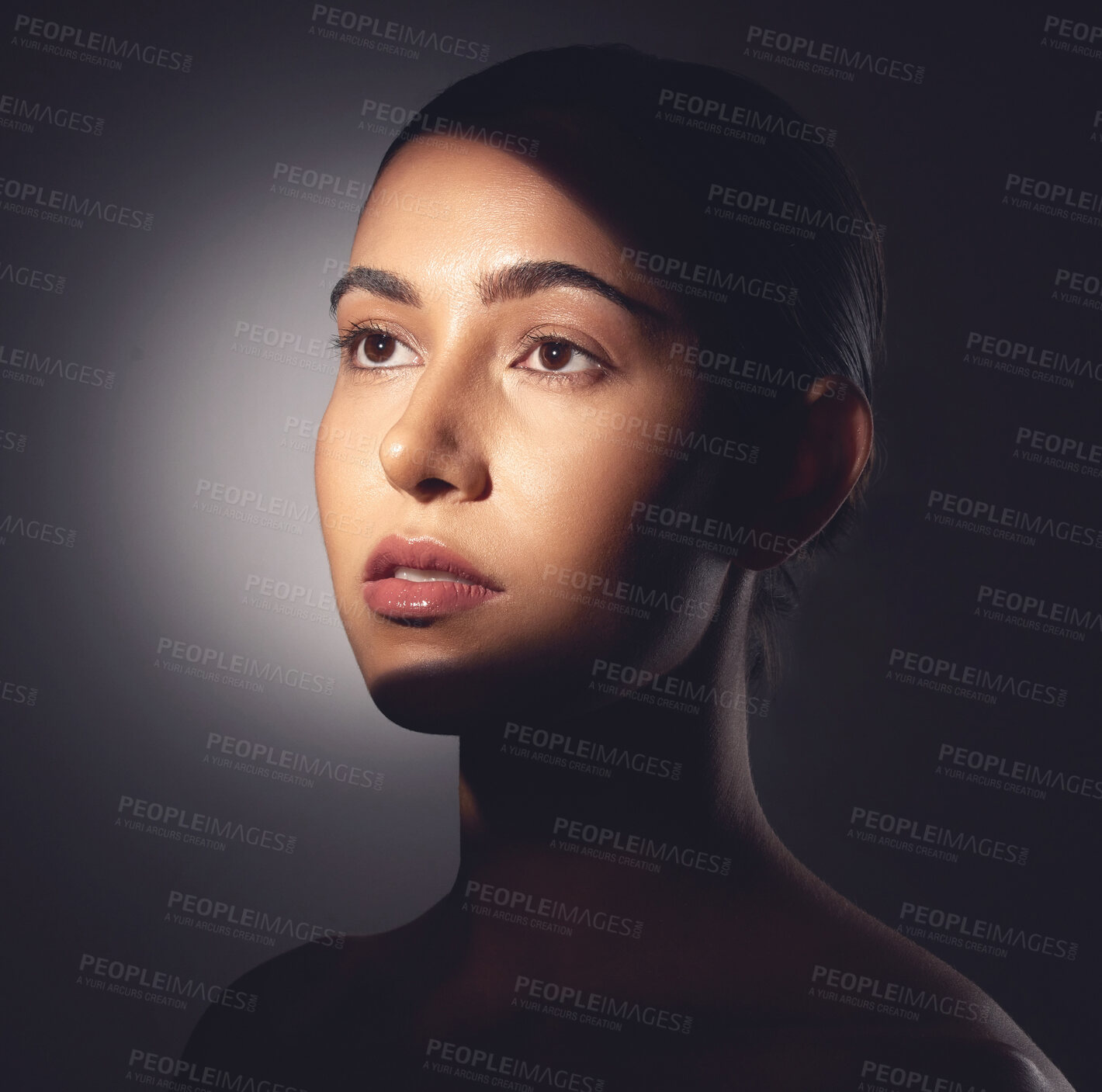 Buy stock photo Studio shot of a beautiful young woman posing with light beam against her face