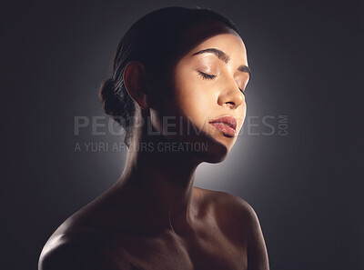 Buy stock photo Studio shot of a beautiful young woman posing with light beam against her face