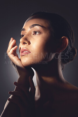 Buy stock photo Studio shot of a beautiful young woman posing with light beam against her face