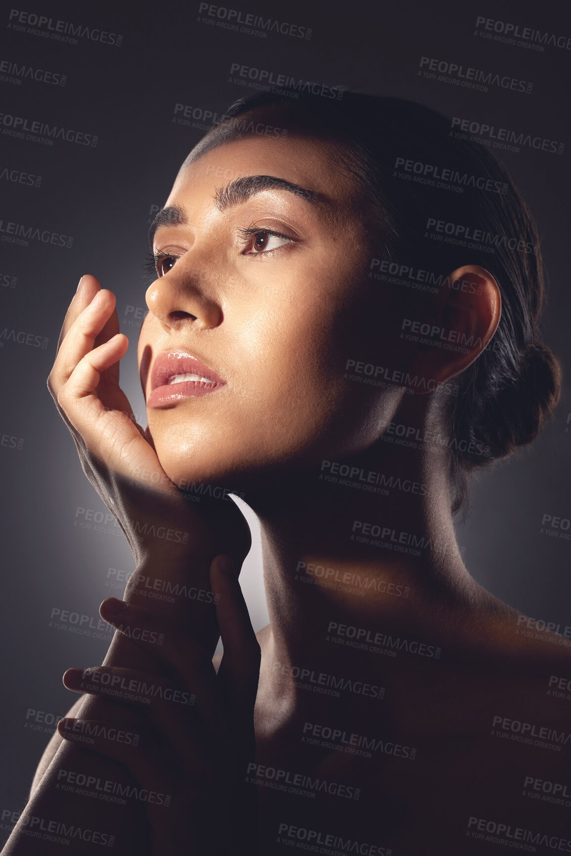 Buy stock photo Studio shot of a beautiful young woman posing with light beam against her face