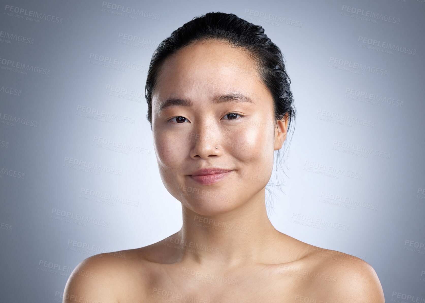 Buy stock photo Shot of a young woman standing against a grey background