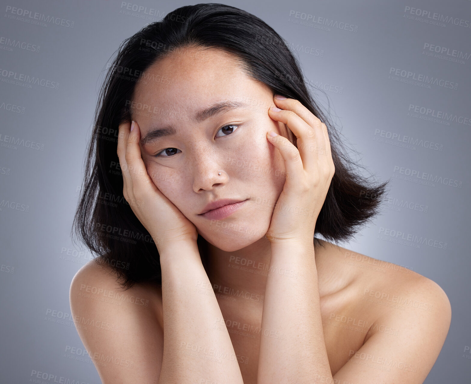 Buy stock photo Shot of a young woman standing against a grey background