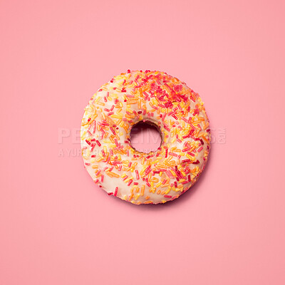 Buy stock photo Colorful, sprinkles and above with donut in studio for unhealthy diet, nutrition and sweet treat. Sugar, circle and creativity with junk food for dessert, calories and snack on pink background