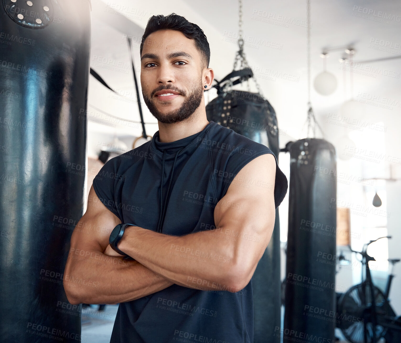 Buy stock photo Portrait of a sporty young woman standing with his arms crossed in a gym