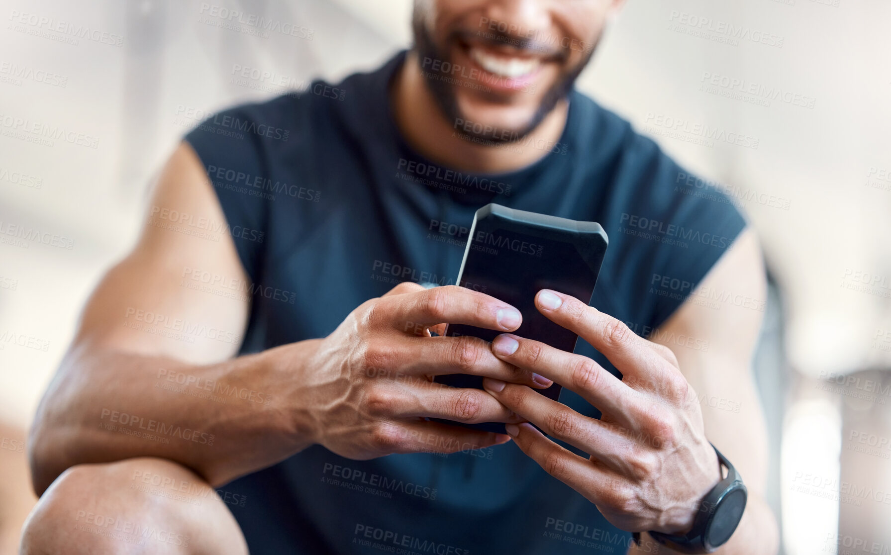 Buy stock photo Low angle shot of an unrecognisable man using a cellphone in a gym