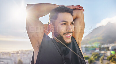 Buy stock photo Shot of a sporty young man stretching while on a rooftop