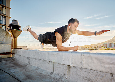 Buy stock photo Shot of a man doing a single-arm plank while on a rooftop