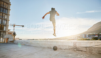 Buy stock photo Shot of a sporty young man out on a rooftop for a workout