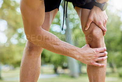 Buy stock photo Closeup shot of an unrecognisable man experiencing knee pain while exercising outdoors