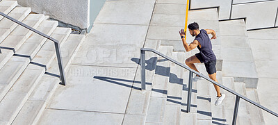 Buy stock photo High angle shot of a sporty young man running up a staircase while exercising outdoors