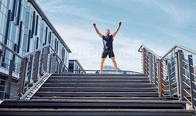 Buy stock photo Low angle shot of a sporty young man cheering at the top of a staircase while exercising outdoors