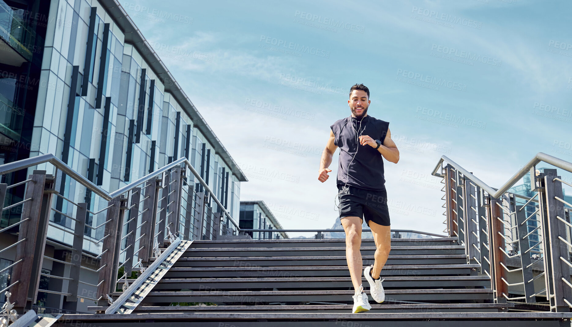 Buy stock photo Low angle shot of a sporty young man running down a staircase while exercising outdoors