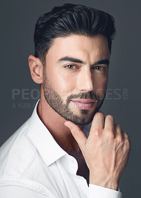 Buy stock photo Studio shot of a handsome young man posing against a grey studio background