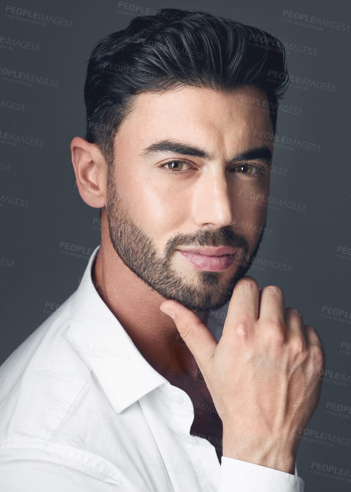 Buy stock photo Studio shot of a handsome young man posing against a grey studio background