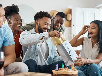 Buy stock photo Shot of a young man opening up gifts on his birthday at home