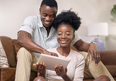 Buy stock photo Shot of a young couple using a digital tablet together at home