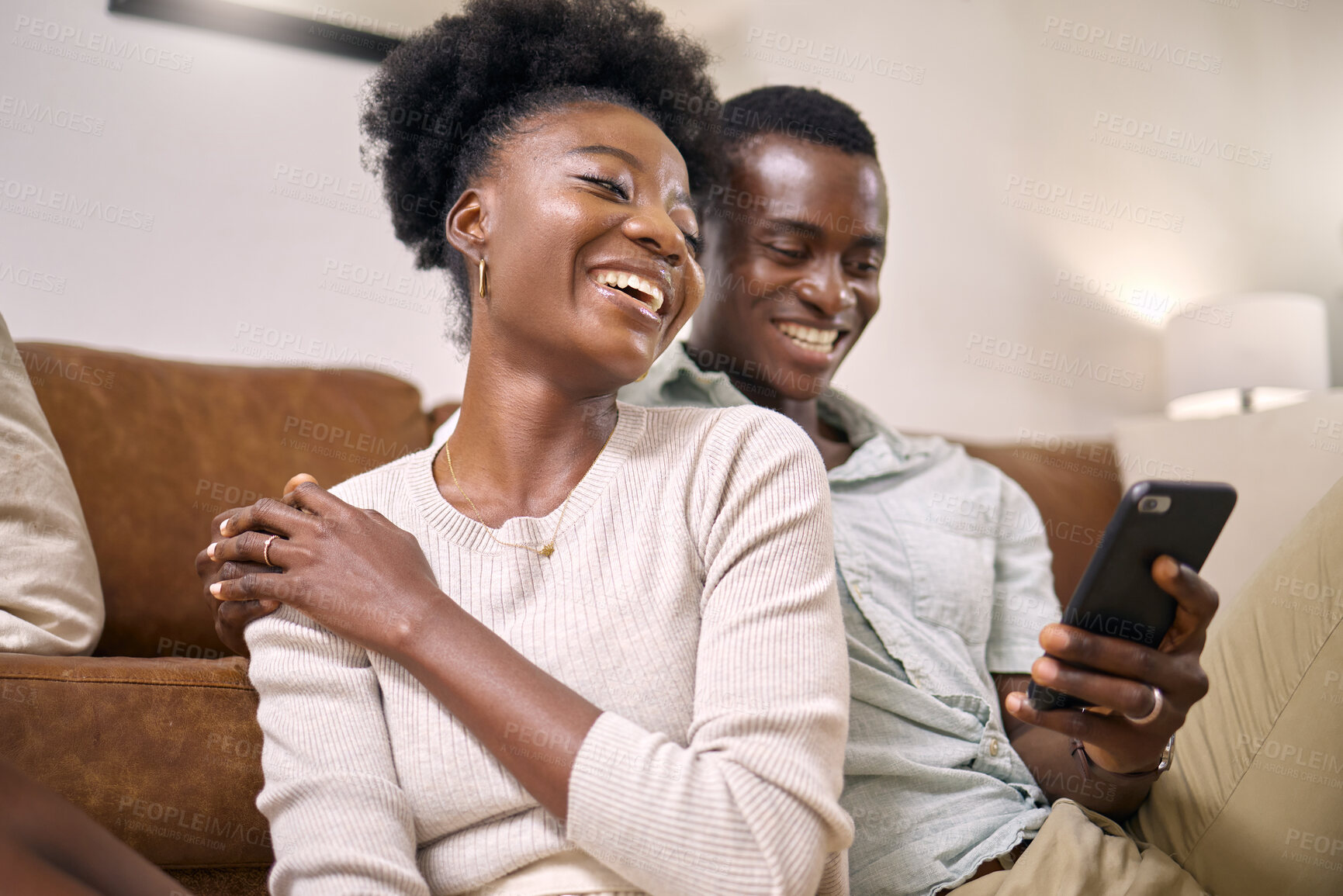 Buy stock photo Shot of a young couple using a phone together at home