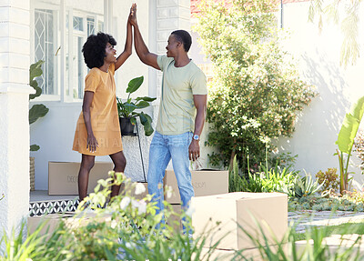 Buy stock photo Shot of a young couple giving each other a high five outside their new house