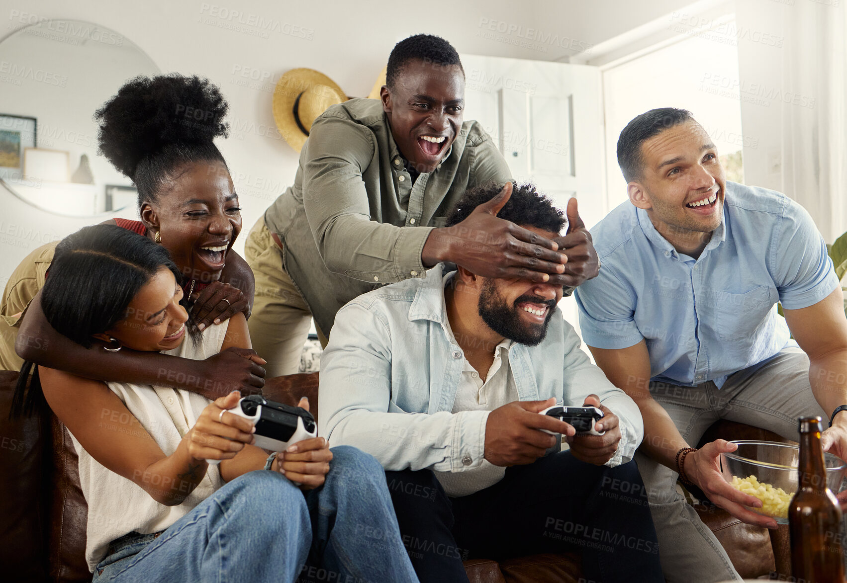 Buy stock photo Shot of two people playing video games while sitting at home with their friends
