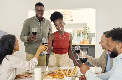 Buy stock photo Shot of a group of people sharing a toast around the dining table in a house