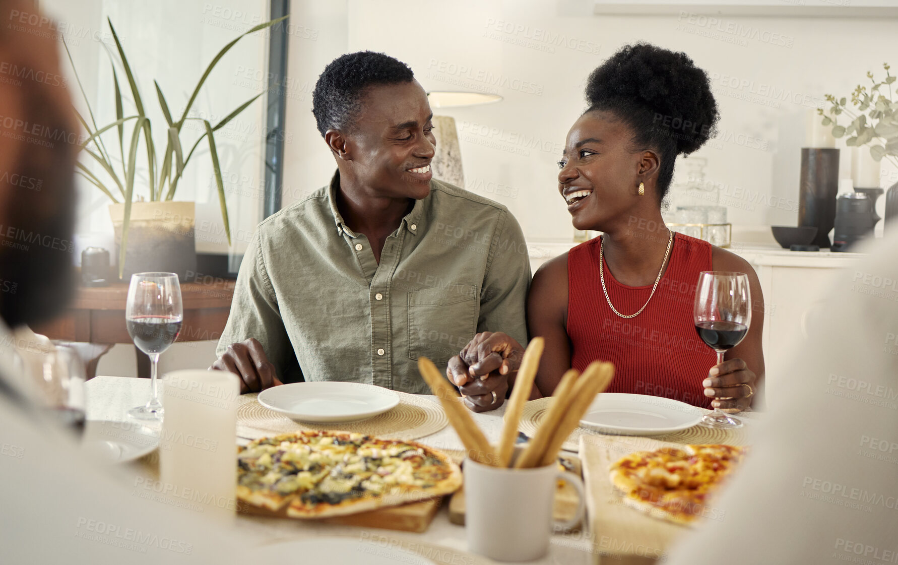 Buy stock photo Shot of an affectionate couple sitting together at a dining table