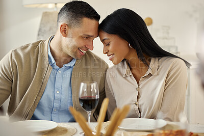 Buy stock photo Shot of an affectionate couple sitting together at a dining table