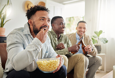 Buy stock photo Shot of three male friends watching something together while sitting on a couch