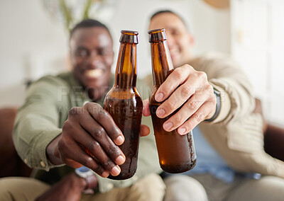 Buy stock photo Shot of two male friends drinking beer while sitting together