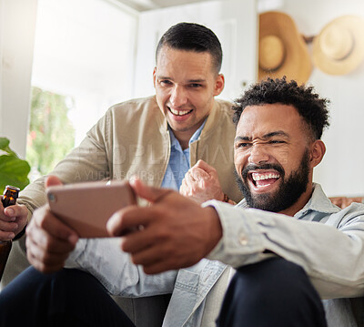 Buy stock photo Shot of two men laughing while looking at something on a cellphone