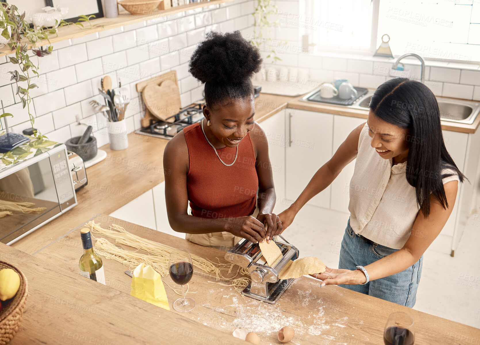 Buy stock photo Shot of two young friends cooking together at home