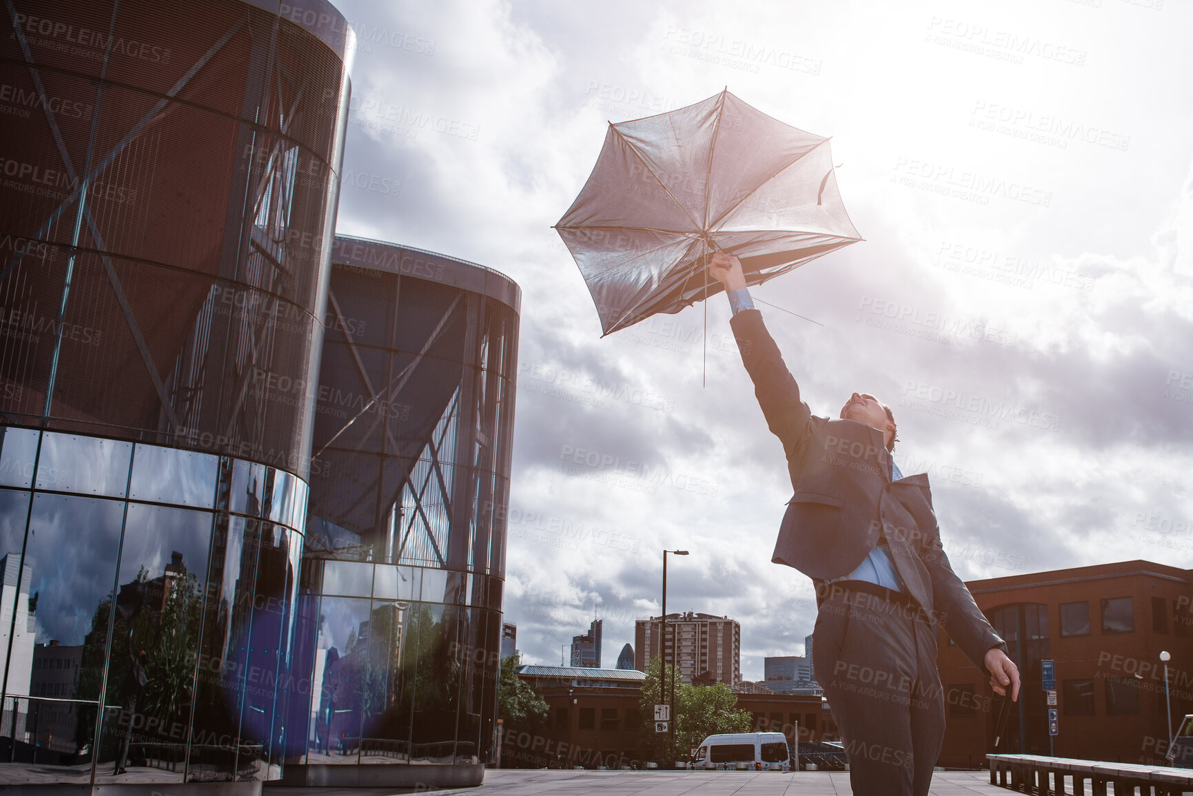 Buy stock photo Businessman, wind and outdoor city with umbrella, insurance agent and risk for security fail. Male person, travel and urban employee for bankruptcy danger, professional investment and liability