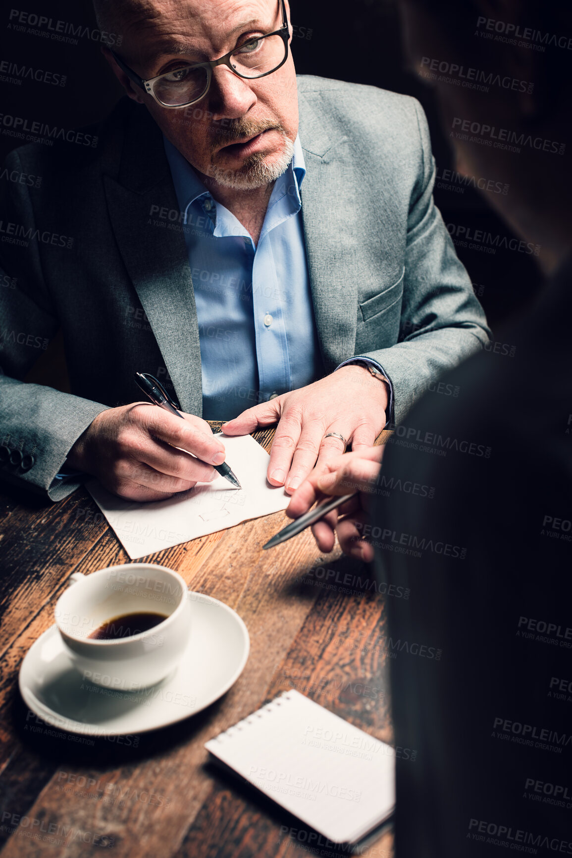 Buy stock photo Shot of a mature businessman discussing contracts with a coworker