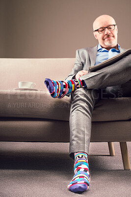 Buy stock photo Shot of a mature businessman relaxing and enjoying coffee while reading a newspaper