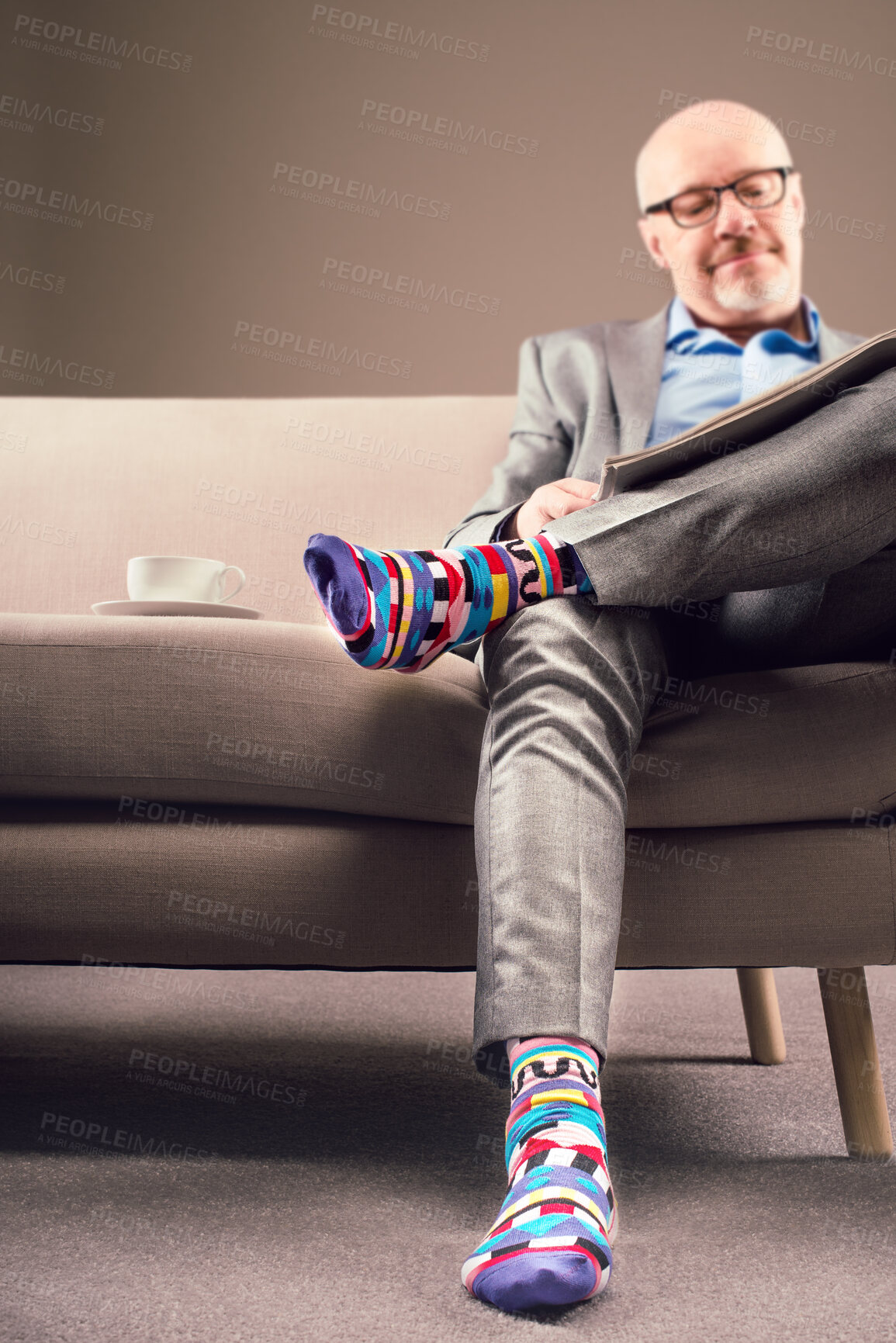 Buy stock photo Shot of a mature businessman relaxing and enjoying coffee while reading a newspaper