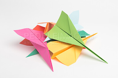 Buy stock photo Paper, creative and colorful with plane in studio for artistic, invention and design of craft. Geometric, shape and stack with jet by white background for handmade origami, aerodynamic and fight