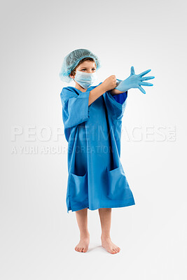 Buy stock photo Little boy, scrub and gloves with mask or uniform in studio for surgery or healthcare on a white background. Child, kid or junior surgeon with latex in prepration for safety, protection or procedure