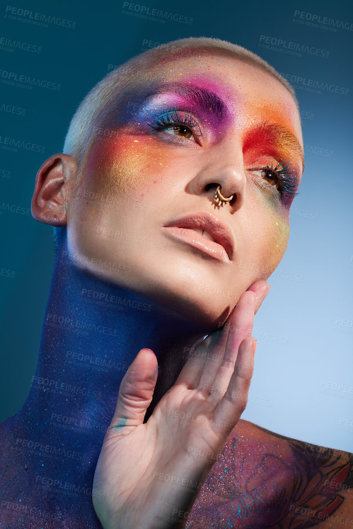 Buy stock photo Studio shot of a young woman posing with multi-coloured paint on her face