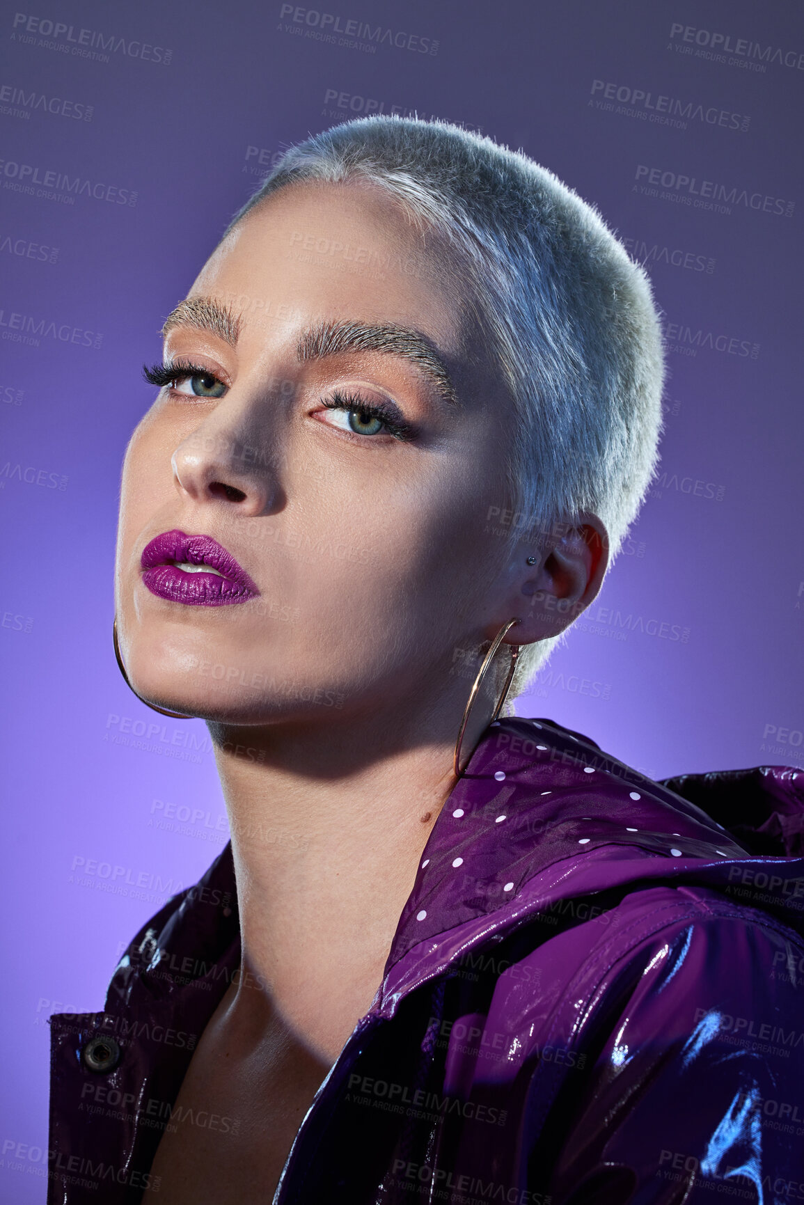 Buy stock photo Shot of a beautiful young woman posing against a purple background