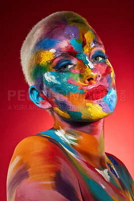 Buy stock photo Studio shot of a young woman posing with multi-coloured paint on her face