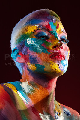 Buy stock photo Studio shot of a young woman posing with multi-coloured paint on her face