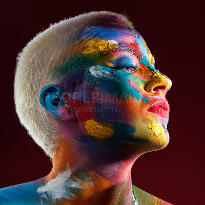 Buy stock photo Studio shot of a young woman posing with multi-coloured paint on her face