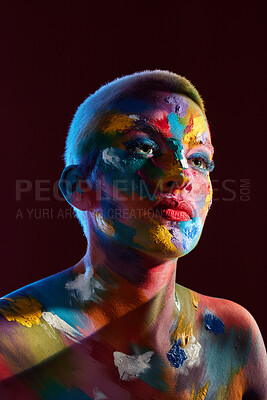 Buy stock photo Studio shot of a young woman posing with multi-coloured paint on her face