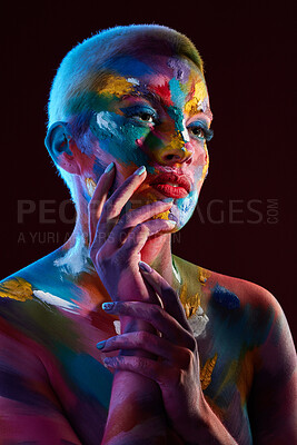 Buy stock photo Studio shot of a young woman posing with multi-coloured paint on her face