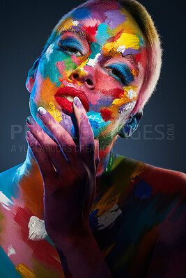 Buy stock photo Studio shot of a young woman posing with multi-coloured paint on her face