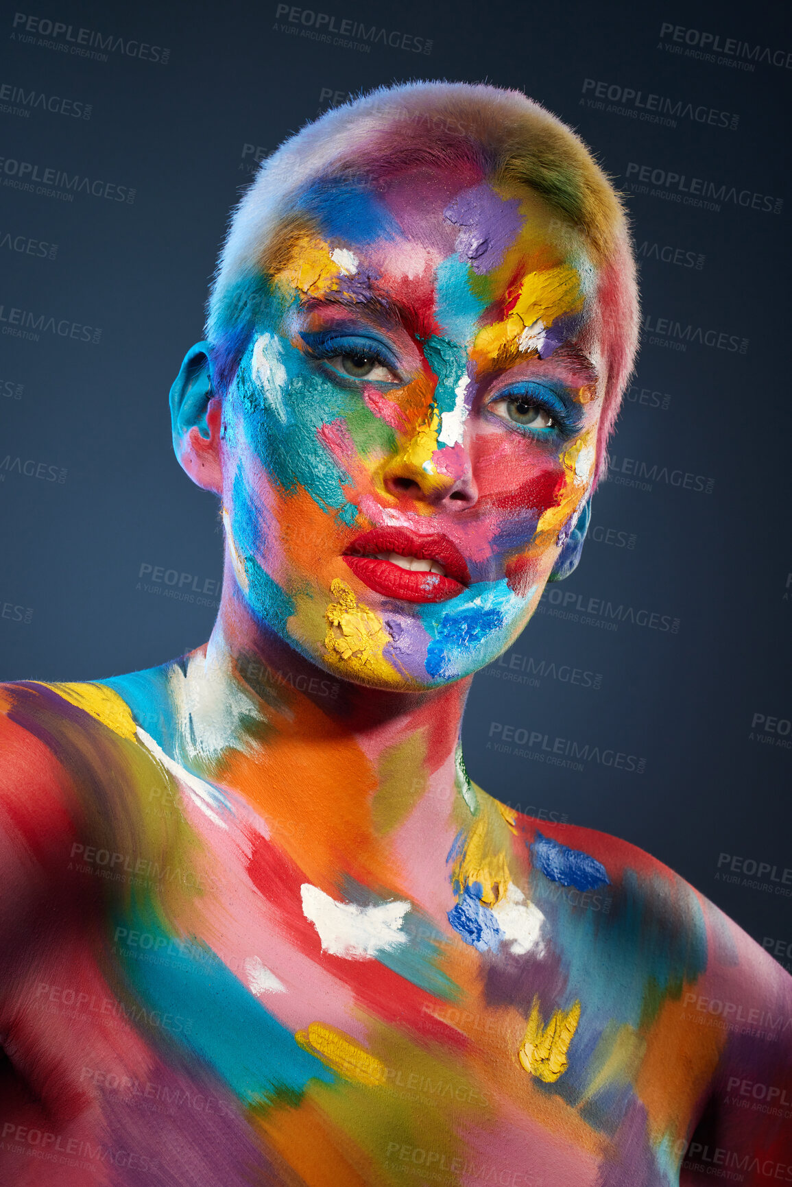 Buy stock photo Studio shot of a young woman posing with multi-coloured paint on her face